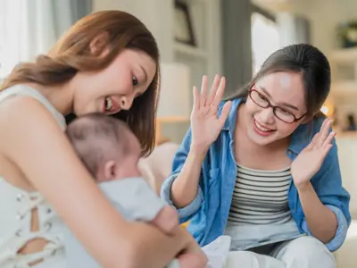 Caregiver talking with infant in mother's arms